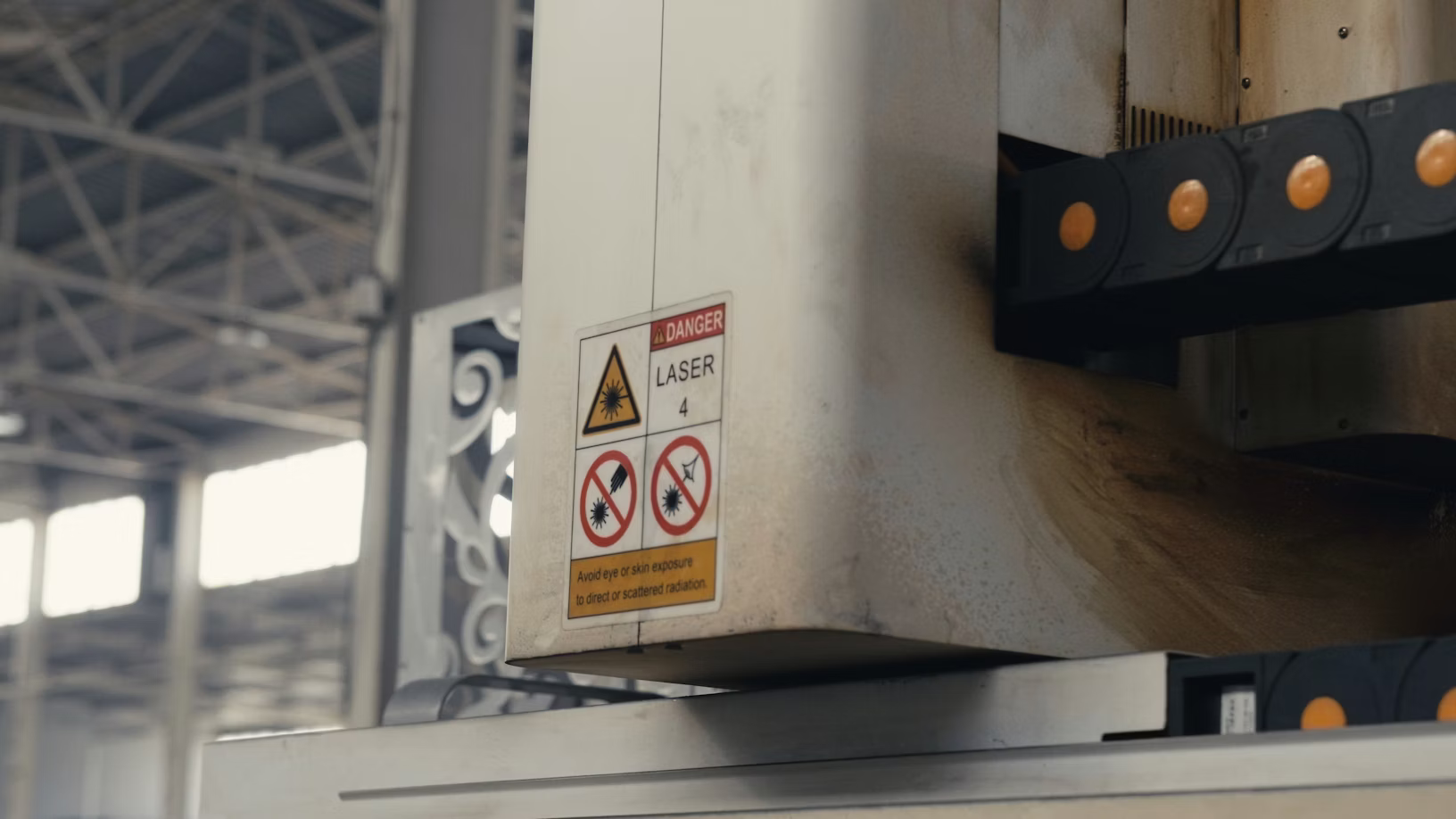 DANGER laser warning label on industrial equipment — LOTO gap analysis identifies all energy source hazards